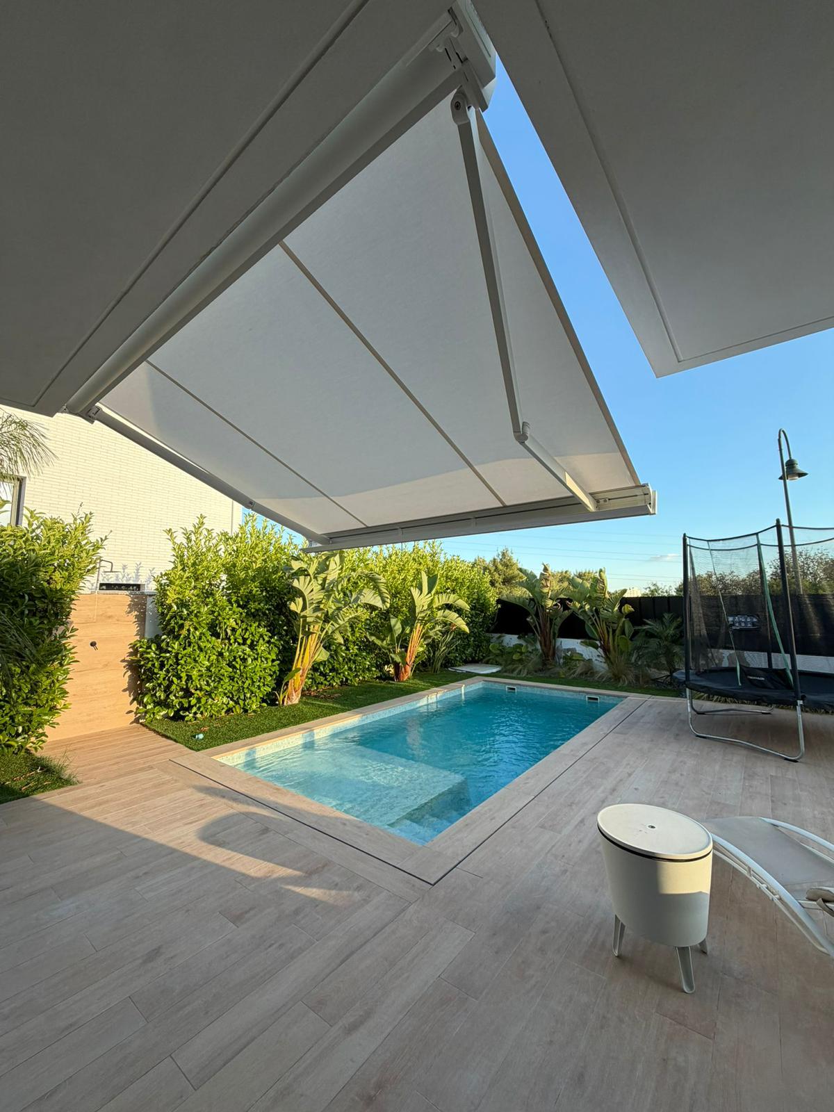 Toldo blanco sobre terraza con piscina