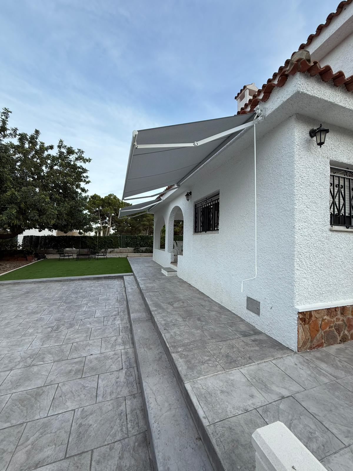 Toldo cofre gris en lateral de chalet